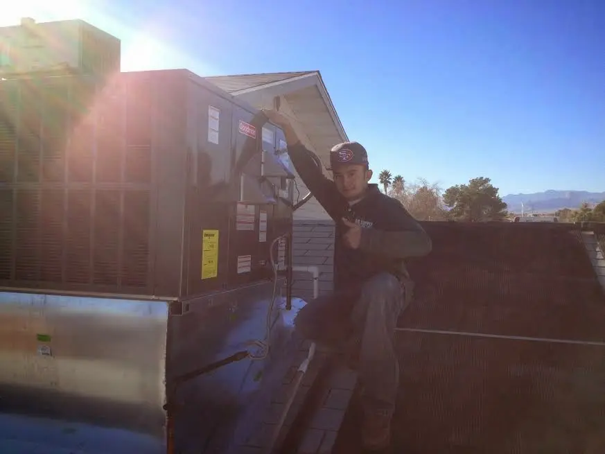 HVAC technician performing Heat Pump Repair on a rooftop unit in Martinsburg